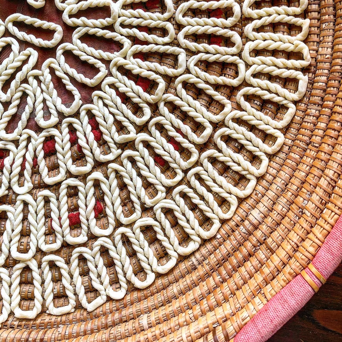 Hand-shaped pasta drying on a woven tray